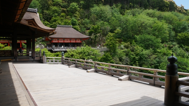 The wooden Kiyomizu Stage supported by tall zelkova pillars, extending from the Main Hall over the hillside.