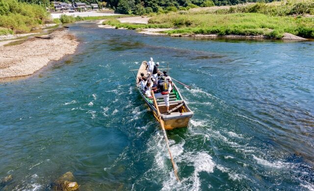 Boatmen navigating rapids during the Hozugawa River Boat Ride